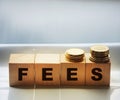 Wooden cbes with fees word and coins on gray background. Taxes and fees business concept Royalty Free Stock Photo