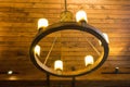 Wooden ceiling and vintage chandelier with electric bulbs. Classic luxury home architecture