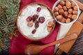 Wooden and ceramic bowls with yogurt and nuts on red napkin on wooden table. Royalty Free Stock Photo