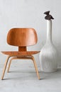 Wooden chair and big white vase over concrete wall. Vertical photo. Cozy interior accessories
