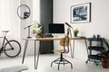 Wooden chair at desk with desktop computer in bright workspace i Royalty Free Stock Photo