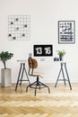 Wooden chair at desk with desktop computer in white home office interior with plants. Real photo Royalty Free Stock Photo