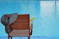 Wooden chair with a hat and lemonade by the pool Royalty Free Stock Photo