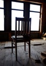 a wooden chair from the last century stands alone in the attic of a house opposite the window Royalty Free Stock Photo