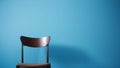 A wooden chair near a wall painted blue, space for a replica. Royalty Free Stock Photo