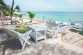 Wooden chair and white table for relaxing under the tree by the beach. Royalty Free Stock Photo