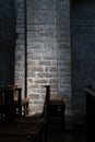 Wooden Chairs in a Dark Church, Subtle Lighting on Stone Wall