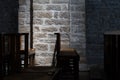 Wooden Chairs in a Dark Church, Subtle Lighting on Stone Wall