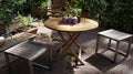 Wooden chairs and wooden deck table surrounded by flower beds in inner yard patio garden Royalty Free Stock Photo