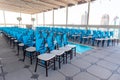 Wooden chairs decorated with blue fabric in an empty wedding hall