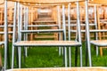 Wooden chairs outside in the park in the rain. Empty auditorium, grass and water drops Royalty Free Stock Photo