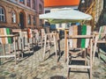 Wooden chairs and table on a cobbled street. Outdoor restaurant terrace cafe in the center of Timisoara city, Romania Royalty Free Stock Photo