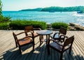 Wooden chairs and table on open seaside terrace