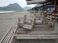 wooden chairs and tables placed in front of a beachside stall