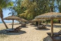 Wooden chairs and umbrellas on white sand beach Royalty Free Stock Photo