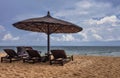 Wooden chairs and umbrellas on white sand beach Royalty Free Stock Photo