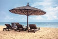 Wooden chairs and umbrellas on white sand beach Royalty Free Stock Photo