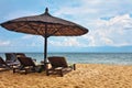 Wooden chairs and umbrellas on white sand beach Royalty Free Stock Photo