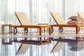 Wooden chaise lounges with mattresses against wide window in home indoor pool Royalty Free Stock Photo