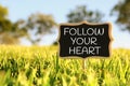 Wooden chalkboard sign with quote: FOLLOW YOUR HEART