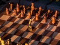Wooden chess board with wooden pieces with sunlight Royalty Free Stock Photo