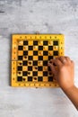Wooden chess board and woman`s hand making chess move Royalty Free Stock Photo