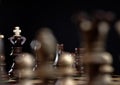 Wooden chess game with focus on the king with unfocused chess pieces in the foreground Royalty Free Stock Photo