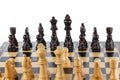 Wooden chess. Chess pieces arranged on a chessboard. Isolated on white background. Close-up Royalty Free Stock Photo