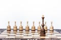 Wooden chess pieces on a chessboard, black queen and white pawns on the background, leadership retro concept Royalty Free Stock Photo