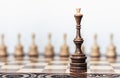 Wooden chess pieces on a chessboard, black queen and white pawns on the background, leadership retro concept Royalty Free Stock Photo