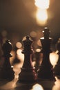 Wooden chess pieces on the chessboard and dim light Royalty Free Stock Photo