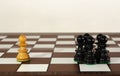 Wooden chess pieces grouped and single one