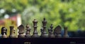 Wooden chess pieces on a wooden chessboard outdoor at the sunny Royalty Free Stock Photo