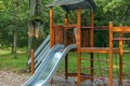 Wooden children playground with slide, ladder, bridge in the forest. Royalty Free Stock Photo