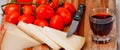 Wooden chopping board with cherry tomatoes, cheese and a glass of red wine Royalty Free Stock Photo