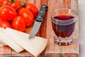 Wooden chopping board with cherry tomatoes, cheese and a glass of red wine Royalty Free Stock Photo