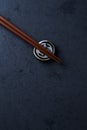 Wooden chopsticks and chopstick rest on dark stone background. Top view. Royalty Free Stock Photo