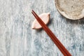 Wooden chopsticks and chopstick rest on rustic wooden background. Top view. Royalty Free Stock Photo