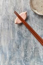 Wooden chopsticks and chopstick rest on rustic wooden background. Top view. Royalty Free Stock Photo