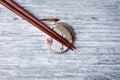 Wooden chopsticks and chopstick rest on rustic wooden background. Top view. Royalty Free Stock Photo