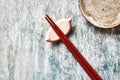 Wooden chopsticks and chopstick rest on rustic wooden background. Top view. Royalty Free Stock Photo