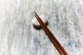 Wooden chopsticks and chopstick rest on rustic wooden background. Top view. Royalty Free Stock Photo