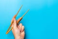 Wooden chopsticks in male hand on black background with empty space for your idea. Tasty food concept Royalty Free Stock Photo