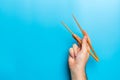 Wooden chopsticks in male hand on black background with empty space for your idea. Tasty food concept Royalty Free Stock Photo