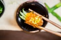 Wooden chopsticks tongs Gunkan Maki Sushi with salmon caviar Ikura and cucumber Royalty Free Stock Photo