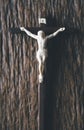 Wooden Christian cross crucifix on a grunge board background. Wooden Christian cross on grey table against blurred lights, space Royalty Free Stock Photo
