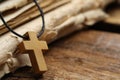 Wooden Christian cross and old Bible on table, closeup. Space for text Royalty Free Stock Photo