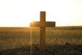 Christian cross outdoors at sunrise. Religion concept
