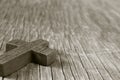 Wooden Christian cross on a rustic wooden surface, sepia toning Royalty Free Stock Photo