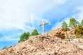 Wooden Christian cross towers on a stone rock on the background of a blue sky with clouds Royalty Free Stock Photo